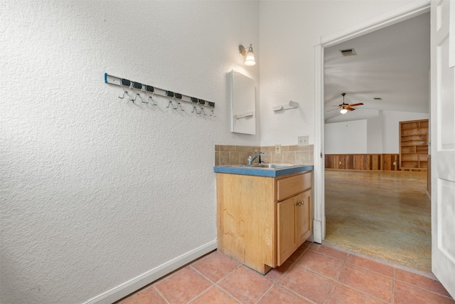 bathroom featuring tile patterned floors, vanity, ceiling fan, and lofted ceiling