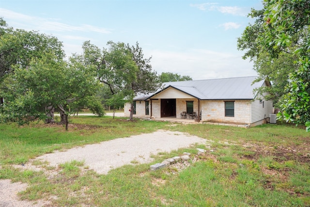 ranch-style house featuring central air condition unit and a front lawn