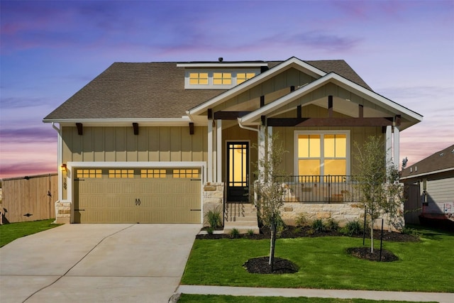 craftsman-style home featuring a garage and a lawn