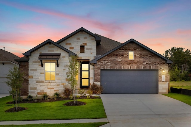 view of front of home with a garage and a lawn