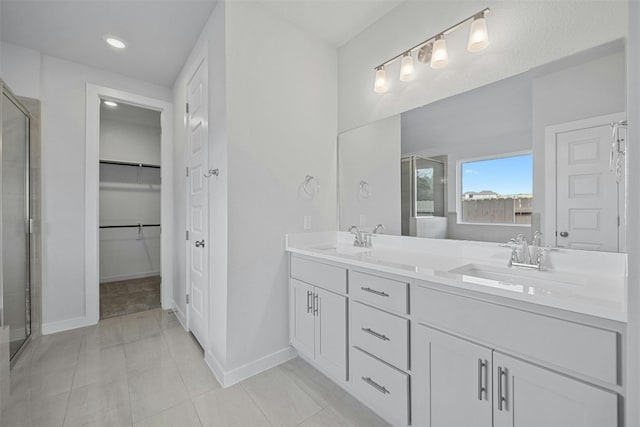 bathroom with tile patterned flooring, vanity, and a shower with door