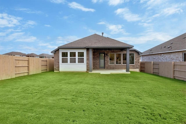 back of house featuring a lawn and a patio area