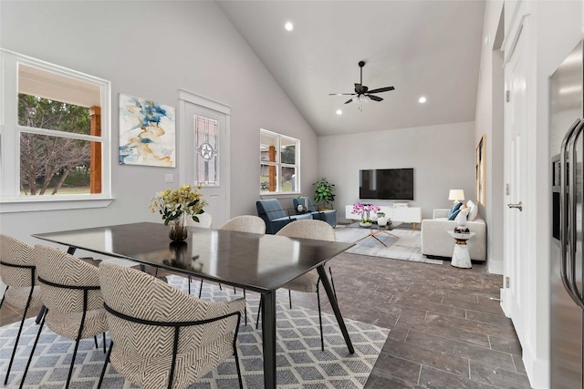 dining area with high vaulted ceiling, ceiling fan, and dark hardwood / wood-style floors