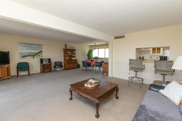 living room featuring a textured ceiling and light colored carpet