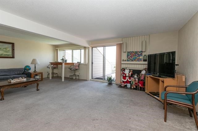 carpeted living room with beamed ceiling and a textured ceiling