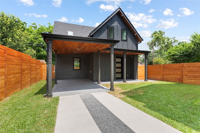 rear view of property featuring a yard and a carport