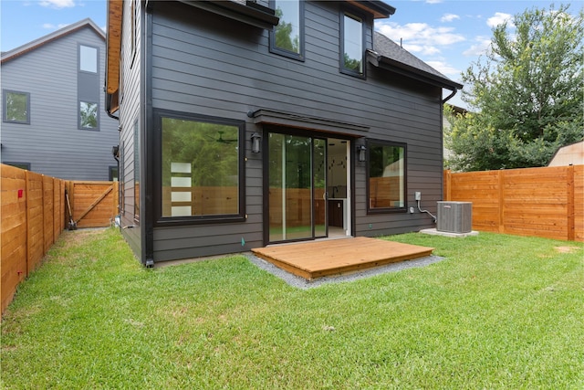 back of house with a wooden deck, central AC unit, and a yard