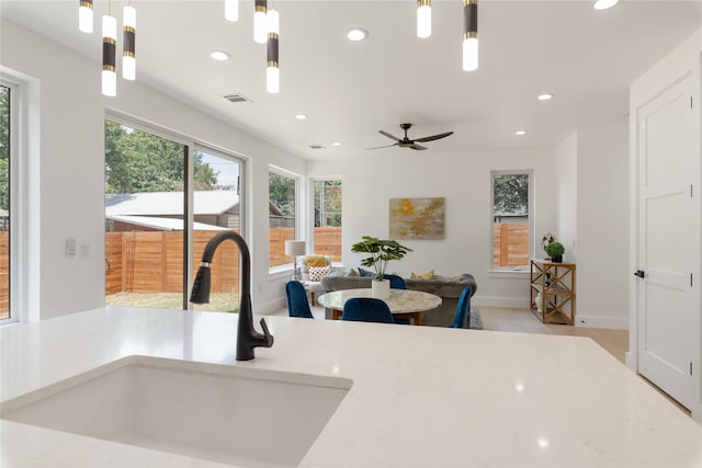 kitchen with light hardwood / wood-style floors, sink, and hanging light fixtures