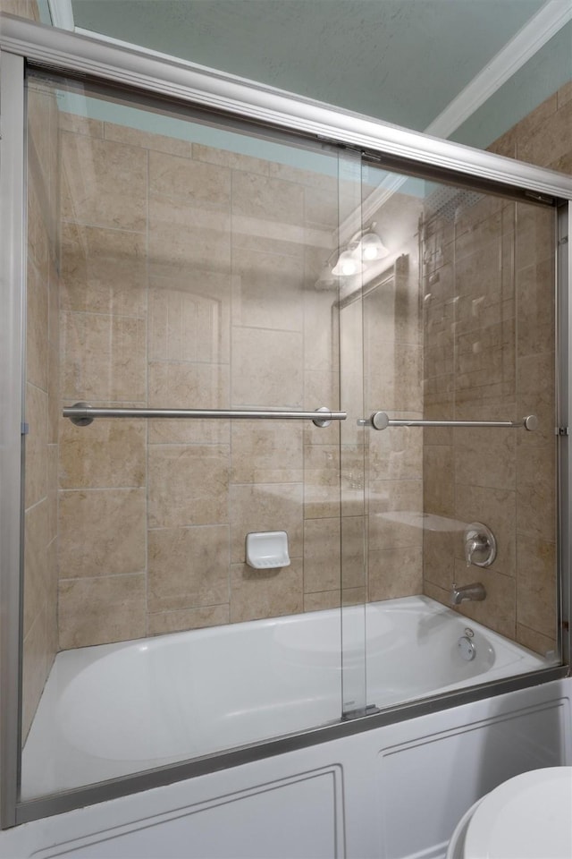 bathroom featuring toilet, crown molding, and enclosed tub / shower combo