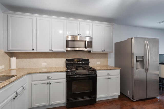 kitchen featuring tasteful backsplash, white cabinetry, light stone countertops, stainless steel appliances, and dark hardwood / wood-style flooring