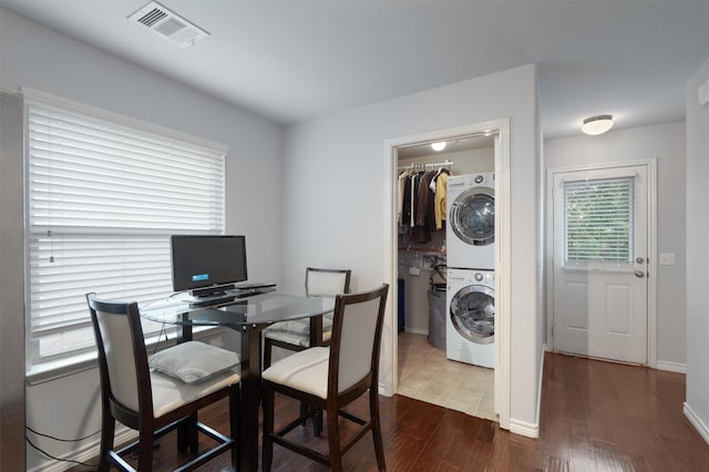 dining area with stacked washing maching and dryer and wood-type flooring