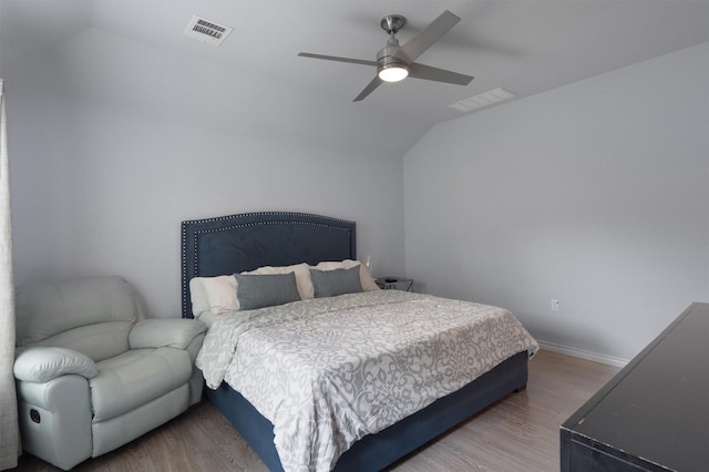 bedroom with ceiling fan, hardwood / wood-style flooring, and vaulted ceiling