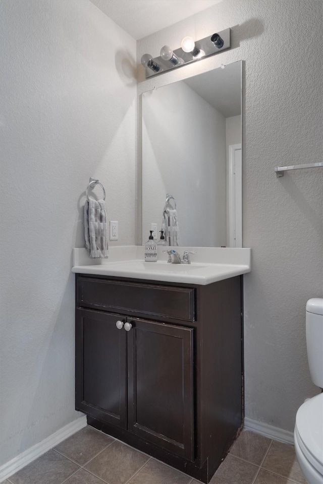 bathroom featuring toilet, vanity, and tile patterned floors