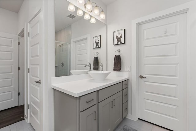 bathroom featuring vanity and a shower with door