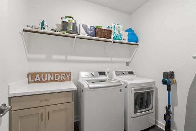 clothes washing area with washer and clothes dryer and cabinets