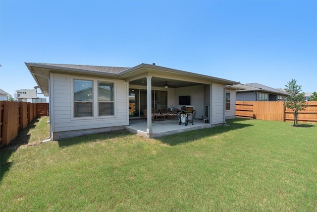 back of property with ceiling fan, a yard, and a patio