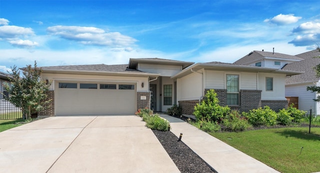 prairie-style house featuring a garage and a front yard