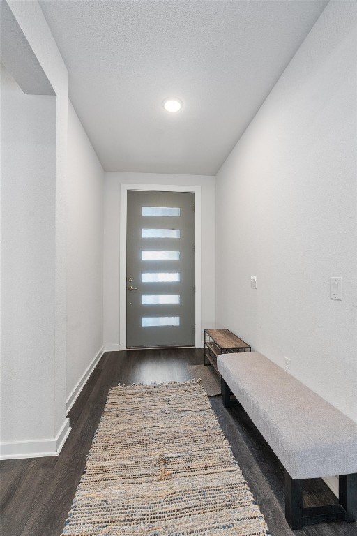 entryway with a textured ceiling and dark hardwood / wood-style flooring