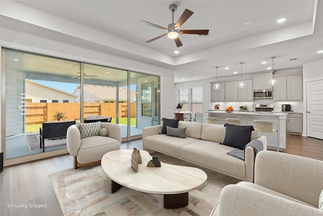 living room featuring ceiling fan and light wood-type flooring