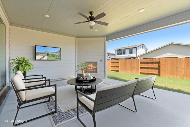 view of patio with an outdoor living space with a fireplace and ceiling fan