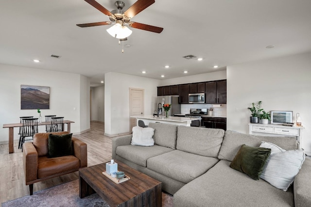 living room featuring hardwood / wood-style floors and ceiling fan