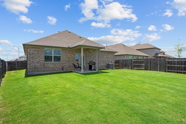 rear view of property featuring a lawn, a patio area, and cooling unit