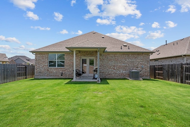 rear view of property with a patio, cooling unit, and a lawn