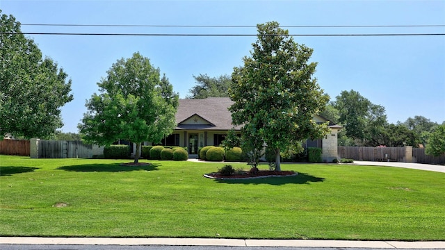 view of property hidden behind natural elements featuring a front lawn