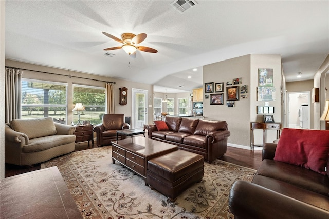 living room featuring a textured ceiling, ceiling fan, light hardwood / wood-style flooring, and lofted ceiling