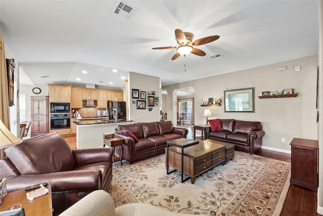 living room featuring ceiling fan, light hardwood / wood-style flooring, and lofted ceiling