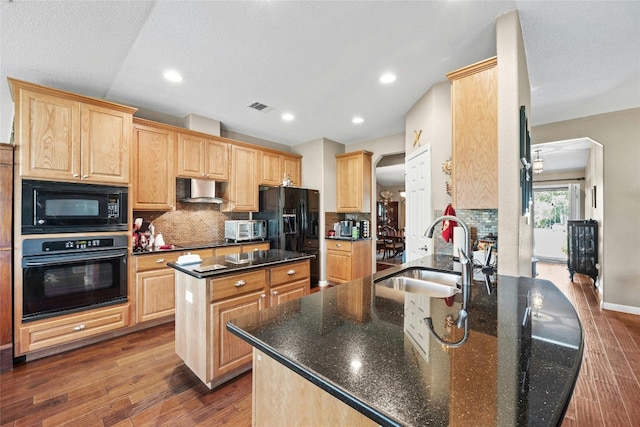 kitchen with light brown cabinets, dark wood-type flooring, black appliances, sink, and a kitchen island