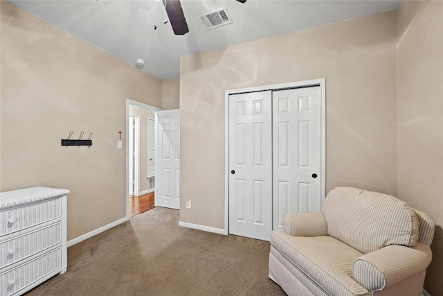 living area with ceiling fan and carpet