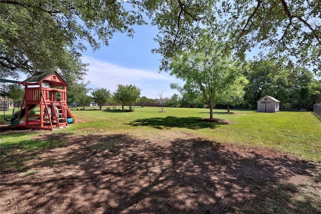 view of yard with a storage shed and a playground