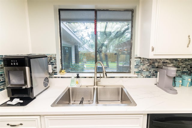 kitchen featuring white cabinetry, dishwasher, sink, and decorative backsplash