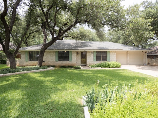 ranch-style home featuring a garage and a front lawn