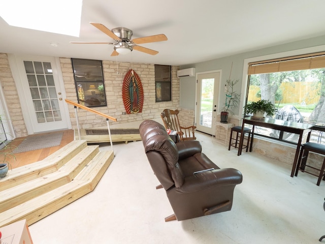 living room with a wall mounted air conditioner, concrete floors, and ceiling fan