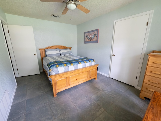 bedroom with ceiling fan and a textured ceiling