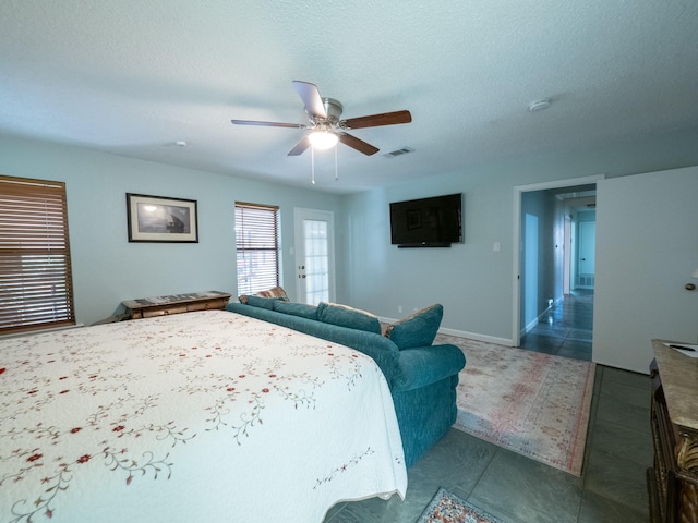 tiled bedroom featuring ceiling fan and a textured ceiling