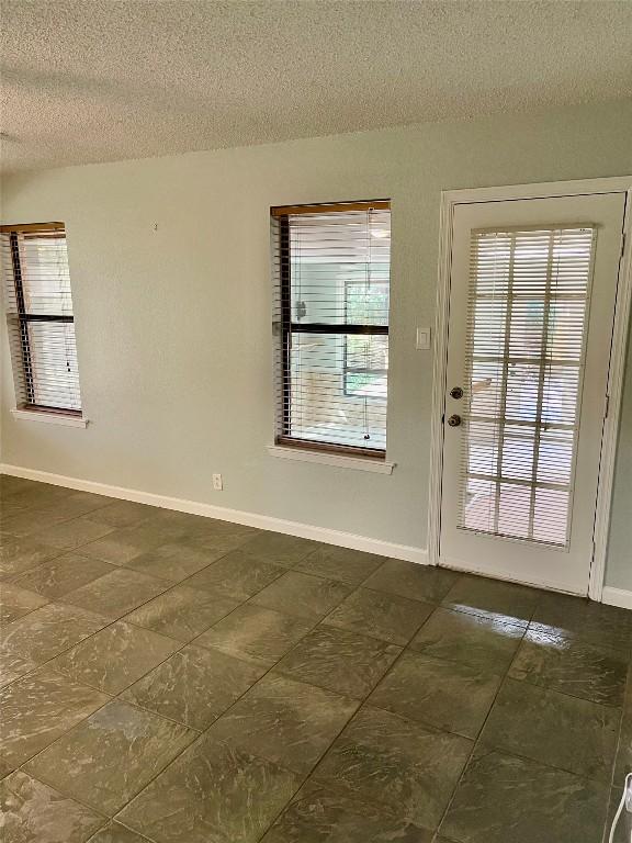 doorway to outside featuring a textured ceiling