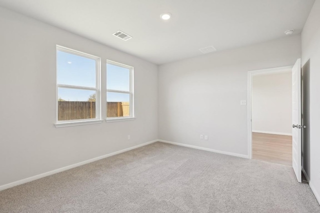 spare room featuring light carpet