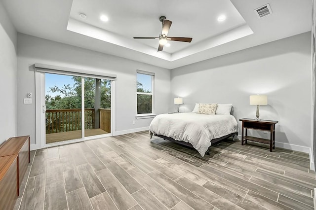 21201 Norris Cv, Lago Vista, TX 78645 - bedroom with access to exterior, a raised ceiling, baseboards, wood finished floors, and recessed lighting
