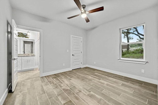 21201 Norris Cv, Lago Vista, TX 78645 - unfurnished bedroom featuring multiple windows, light wood-style flooring, and baseboards
