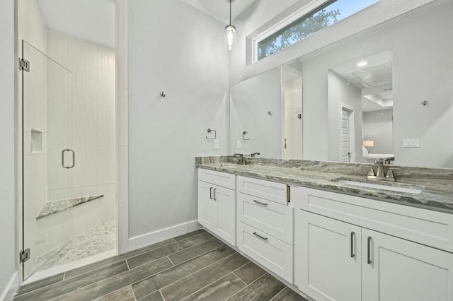 21201 Norris Cv, Lago Vista, TX 78645 - full bathroom featuring a shower stall, double vanity, baseboards, and wood finish floors