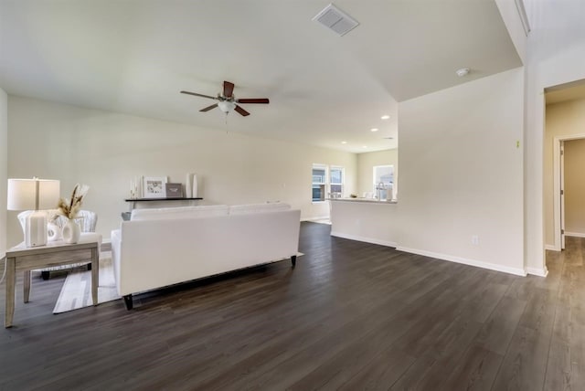 living room with ceiling fan and dark wood-type flooring