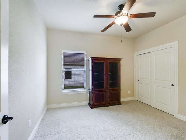 interior space featuring a closet, ceiling fan, and light colored carpet