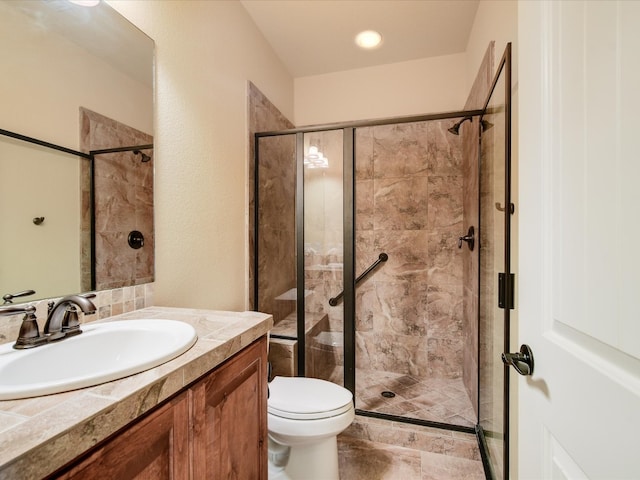 bathroom with a shower with door, vanity, and toilet