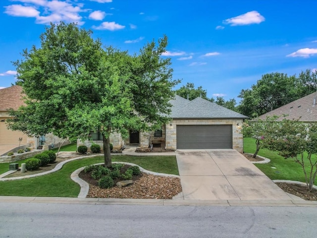 view of property hidden behind natural elements featuring stone siding, an attached garage, driveway, and a front lawn