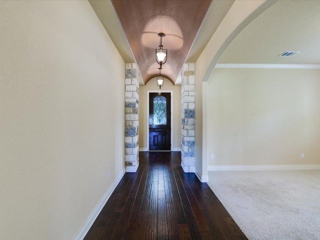 entrance foyer featuring arched walkways, baseboards, and dark wood-style floors