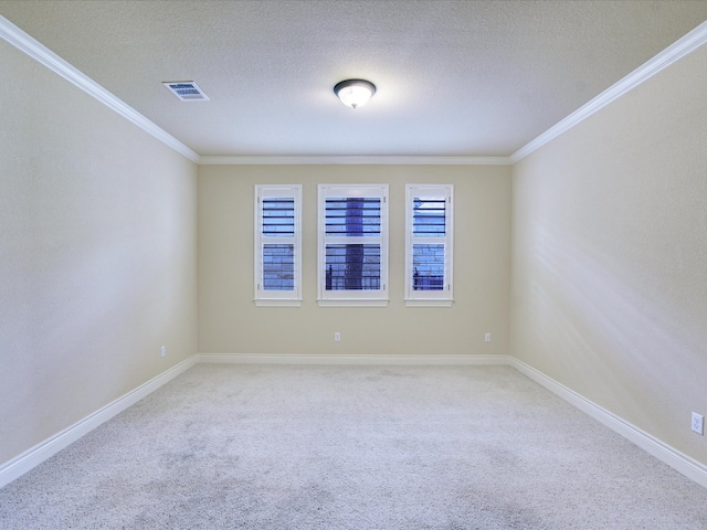 spare room with a textured ceiling, ornamental molding, and carpet floors