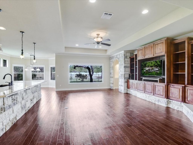 unfurnished living room with a ceiling fan, dark wood finished floors, a sink, arched walkways, and recessed lighting